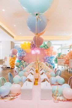 a room filled with lots of balloons and tables