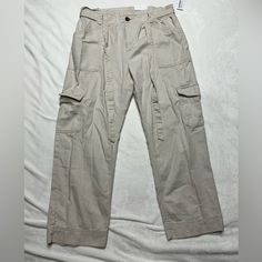 New With Tags Khaki Pants From Old Navy. They Are Wide Leg Pants. They Have A Button And Zipper Closure And Also A Tie At The Waist. There Are Cargo Pockets On The Legs. No Stains Or Rips In Fabric. Never Worn. Khaki High-waist Parachute Pants With Belt Loops, Khaki Summer Bottoms With Flap Pockets, Khaki High-waisted Cargo Jeans In Utility Style, Khaki High-waisted Utility Cargo Jeans, High-waisted Khaki Cargo Jeans In Utility Style, High-waisted Khaki Cargo Jeans Utility Style, Khaki Bottoms With Flap Pockets For Spring, Khaki Pants With Flap Pockets For Spring, High Waist Utility Cargo Jeans With Button Closure