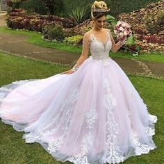 a woman in a wedding dress standing on the grass