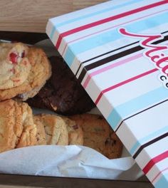 a box filled with chocolate chip cookies next to a bag