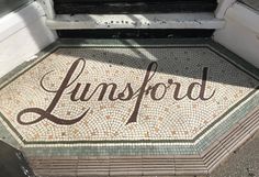 the word lindsford is written on a mosaic tile floor in front of a door