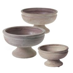 two stone bowls sitting next to each other