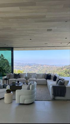 a living room filled with lots of furniture next to a large window overlooking the city