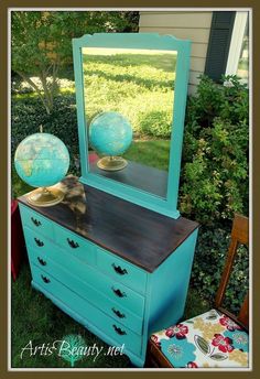 an old dresser with a mirror and globe on top