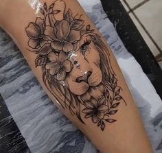 a woman's leg with a lion and flowers on it