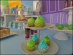 cupcakes and pastries are displayed on three tiered trays