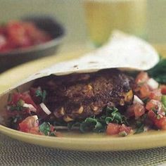 a burrito filled with meat and veggies on top of a yellow plate