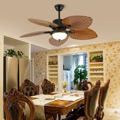 a dining room table with chairs and a ceiling fan in the middle of it's room