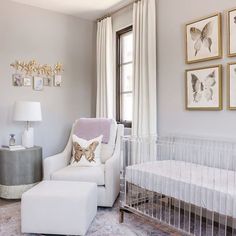 a baby's room with a crib, chair and pictures on the wall