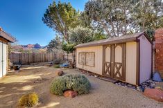 a backyard with a shed, rocks and trees