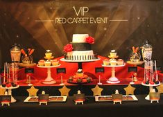 a red carpeted table topped with cakes and desserts