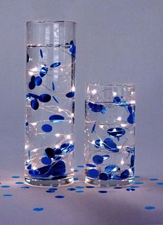 two glasses filled with water and blue flowers