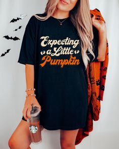 Get ready to be OBSESSED with your new *Expecting A Little Pumpkin* shirt. It's the cutest and most trendy way to emit all those important Halloween Pregnancy vibes!  Great as a Spooky Baby Shower gift! * Q U I C K * F A C T S * ✺ 100% ring-spun cotton ✺  Medium fabric (6.1 oz/yd² (206.8 g/m ✺ Wash and dry normally (on cool for best results) ✺ Product color may slightly vary due to photographic lighting sources or your monitor settings  * S I Z I N G * ✺ Sizing is unisex so runs like men's. ✺ Most women find their typical size works best, since they are meant to fit a touch loose and go up 1 or 2 sizes if you want the oversized look. ✺ Size guide and fit:  The size chart is listed in photos above.  Please use the measurement for the most accurate sizing. * PRINT INFO * ✺ Printed with DTG - Little Sister Gifts, Make Her Smile, Spooky Vibes, Bachelorette Party Shirts, Aunt Gifts, Trendy Shirts, Retro Halloween, Fall Shirts, Party Shirts