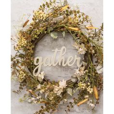 a wreath with the word gather written in white letters on it and some flowers around it