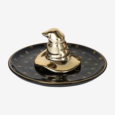 a black and gold plate with a metal faucet on the top that is shaped like a dog