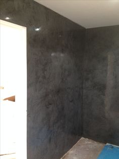 a room that is being painted with dark gray paint on the walls and flooring