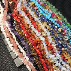 many different colored beads on a black surface