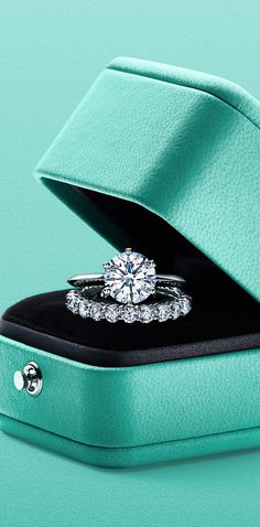 a diamond ring in a green box with a black band around it's edge