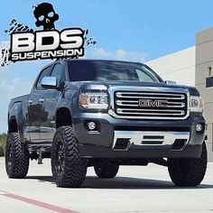 a large truck parked in front of a building with the words bds suspension on it