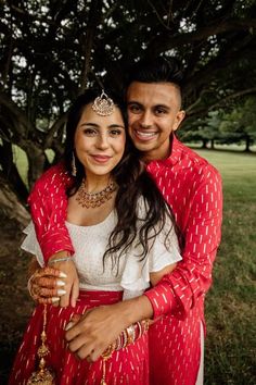 Manisha and Akash stunning in matching red and gold outfits by Harleen Kaur. Designed in a lightweight bold red cotton with a gold foil pattern throughout, perfect for any Indian wedding weekend! Manisha is wearing a tiered red Milly Lehenga Skirt & Akash is wearing a long sleeve red Sumeet Kurta. Explore outfits in red & find Manisha & Akash's client diary at www.harleenkaur.us! Gold Indian Outfit, Indian Clothing Store