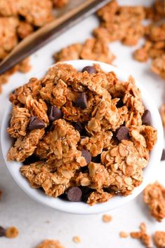 a white bowl filled with granola and chocolate chips