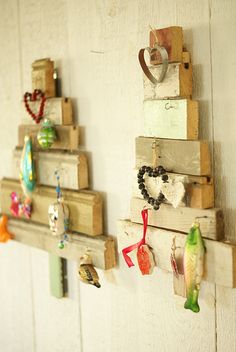 several pieces of wood are hanging on the wall with beads and necklaces attached to them