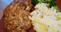 a red plate topped with chicken, mashed potatoes and broccoli