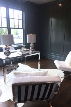 a living room with black walls and white furniture