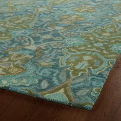 a blue and green rug on top of a wooden floor