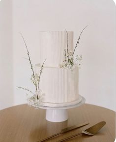 a three tiered white wedding cake with baby's breath flowers on the top