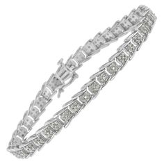 Crafted in 10k white gold, this stunning tennis bracelet features 2ct TDW of glittering round cut diamonds. Each link is inlaid with four prong set diamonds and fans out to fit onto the next one creating a unique effect. A box clasp mechanism keeps it secure. Each genuine stone is round-cut and I3 clarity, which is at the lower end of the diamond color and clarity grading scale; the white diamonds are I-J color, and may appear more grey/brown and cloudy than as seen in images. "Video Available U Luxury Adjustable Tennis Bracelet With Single Cut Diamonds, Classic White Tennis Bracelet With Pave Setting, Diamond White Tennis Bracelet With Pave Setting, White Fine Jewelry Tennis Bracelet With Pave Setting, Fine White Tennis Bracelet With Pave Setting, White Tennis Bracelet With Pave Setting, White Diamond Tennis Bracelet With Diamond Accents, White Diamond Tennis Bracelet With Pave Setting, Diamond White Tennis Bracelet With Pave Setting For Anniversary