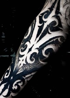 a black and white photo of a man's arm with tattoos on it