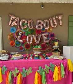 a table with taco bout love sign and decorations on it for a mexican themed party