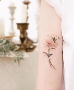 a woman's arm with a flower tattoo on the left side of her arm