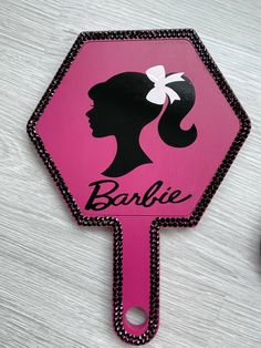 a pink sign with a woman's profile and the word barbie written on it