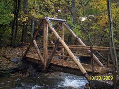 a wooden bridge over a stream in the woods