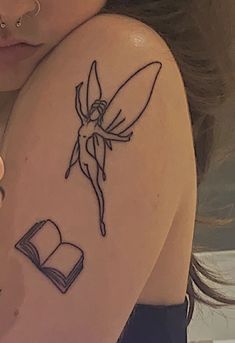 a woman with a tattoo on her arm has a book in front of her shoulder