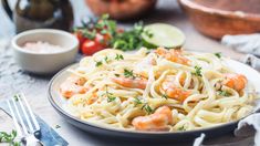 a plate of pasta with shrimp and parsley