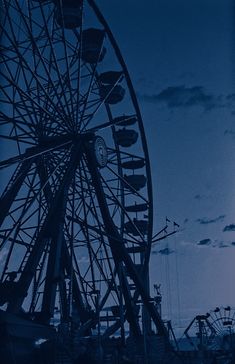 a ferris wheel sitting in front of a full moon