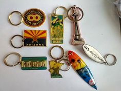 several different key chains and magnets on a white surface, including a bottle opener