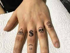 two fingers with tattoos on them, one has an eye and the other has a dollar sign