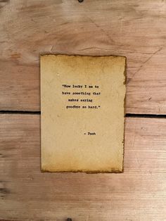 a piece of paper with a quote on it sitting on top of a wooden table