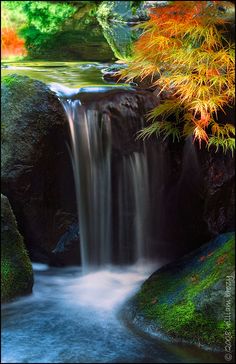 there is a waterfall in the middle of some rocks