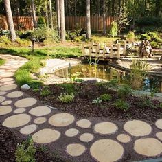 a small pond surrounded by stepping stones in a garden