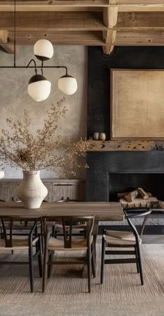 a dining room table and chairs in front of a fire place with an open fireplace