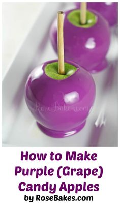 three purple apples with wooden sticks sticking out of the top, sitting on a white surface