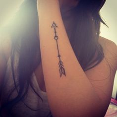 a woman with a small arrow tattoo on her arm