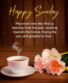 a cup of coffee next to some flowers on a table with the words happy sunday