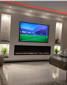 a large flat screen tv mounted on the wall above a fireplace in a living room