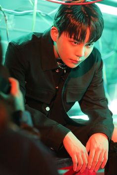 a young man sitting on top of a red chair